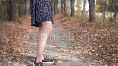 戴眼镜的女孩站在秋天的森林里。 <strong>从头</strong>到脚的全景。